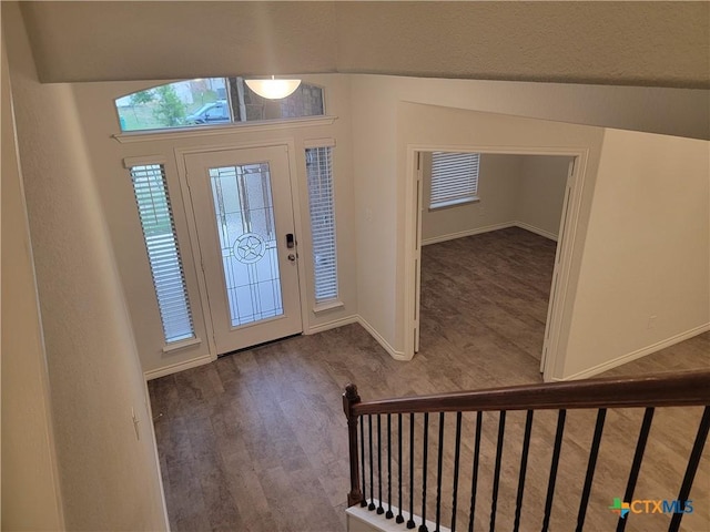 entryway with stairway, wood finished floors, and baseboards