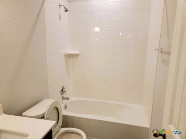 full bathroom with vanity, shower / tub combination, toilet, and a textured wall