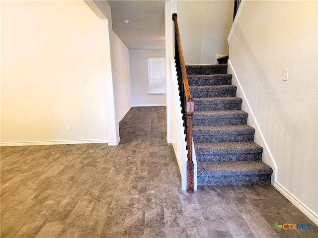 staircase with baseboards and wood finished floors