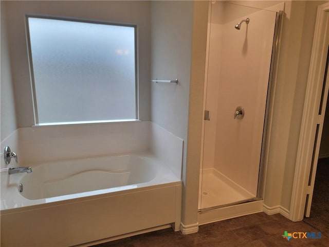 bathroom featuring a bath and a shower stall