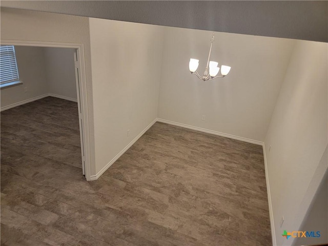 unfurnished dining area featuring baseboards, carpet, and an inviting chandelier