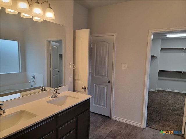 bathroom with double vanity, baseboards, and a sink