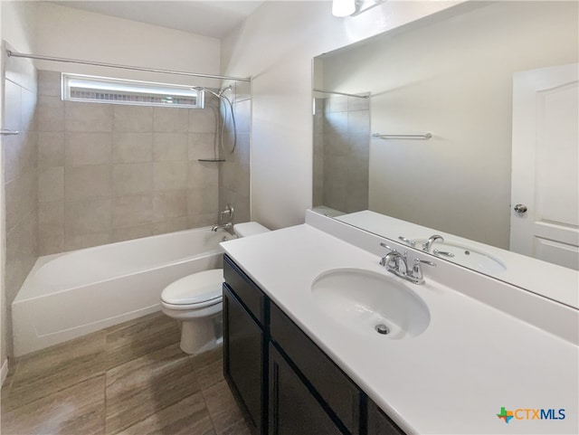 full bathroom with vanity, tiled shower / bath, and toilet