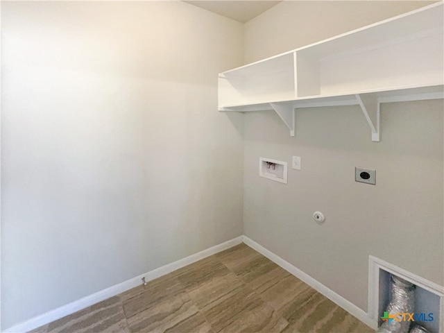 clothes washing area featuring hookup for an electric dryer, washer hookup, hardwood / wood-style flooring, and hookup for a gas dryer