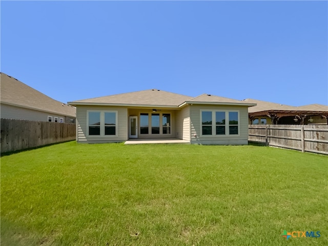 rear view of property featuring a patio and a lawn