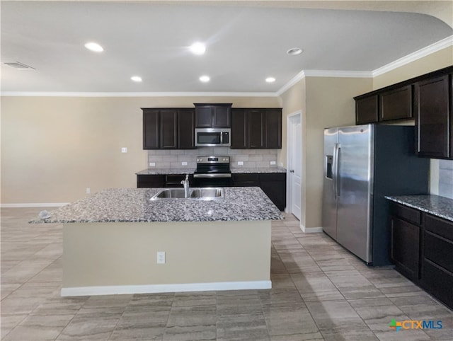 kitchen with a kitchen island with sink, appliances with stainless steel finishes, and light stone countertops