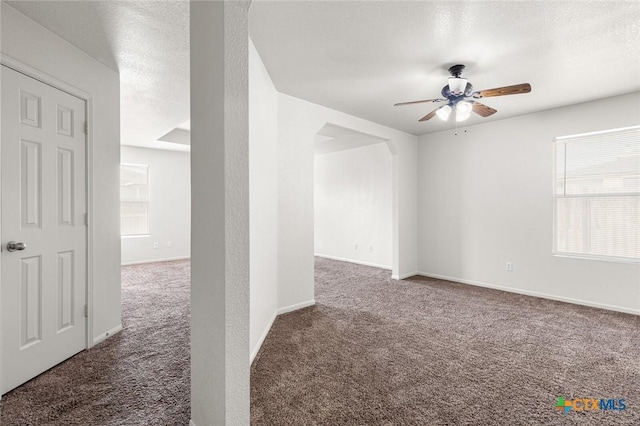 unfurnished room with carpet floors, a textured ceiling, a ceiling fan, and a wealth of natural light