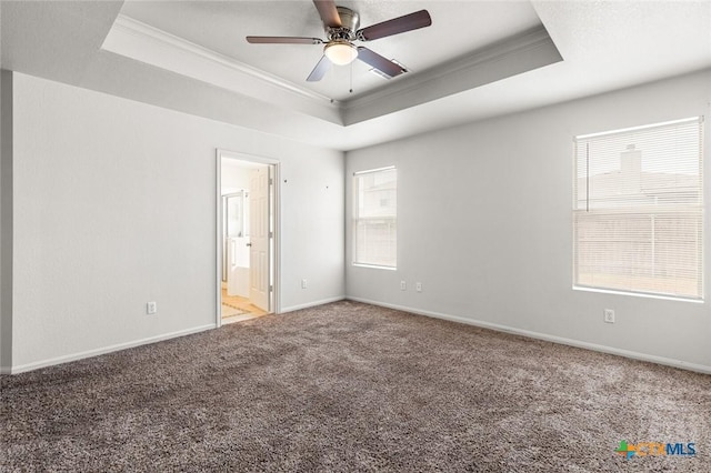 spare room featuring carpet floors, baseboards, ornamental molding, and a raised ceiling