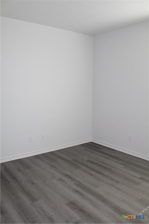 unfurnished room with dark hardwood / wood-style floors