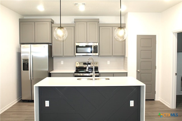 kitchen featuring gray cabinets, sink, decorative light fixtures, and appliances with stainless steel finishes