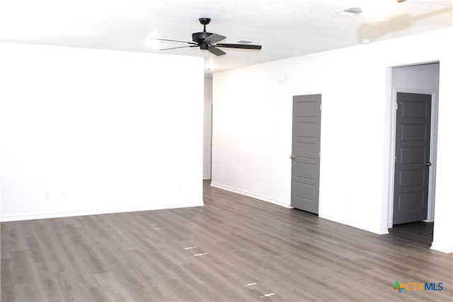 unfurnished room with ceiling fan, dark wood-type flooring, and a textured ceiling