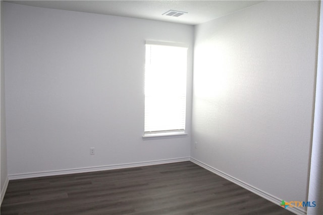 spare room featuring dark wood-type flooring