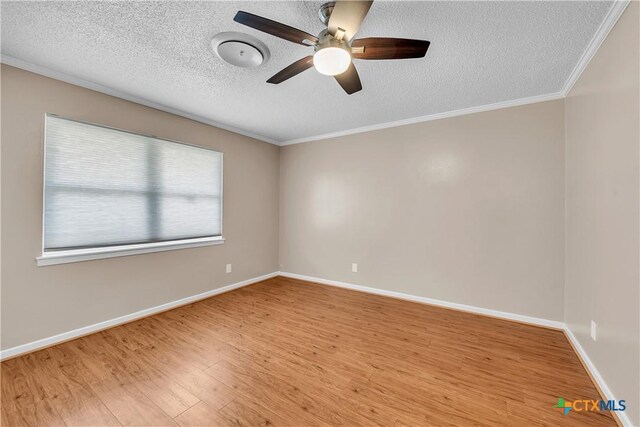 unfurnished room with wood finished floors, a ceiling fan, crown molding, baseboards, and a textured ceiling