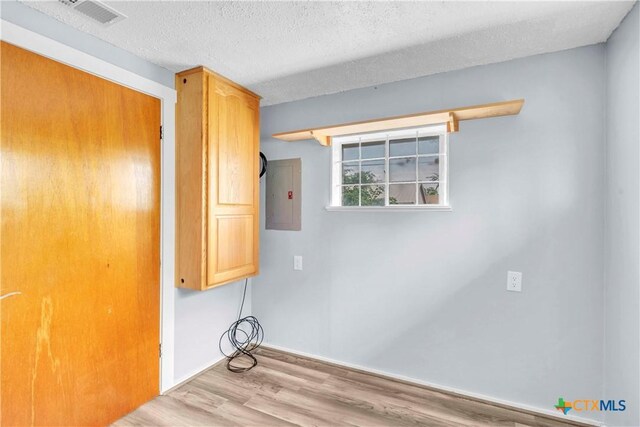 1009 E Robertson Ave, Copperas Cove, TX 76522 - laundry room featuring electric panel, wood finished floors, a textured ceiling, and baseboards