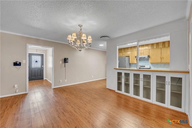 interior space with light wood-style floors, baseboards, a textured ceiling, and a chandelier