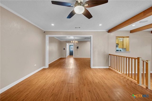 empty room with baseboards, ceiling fan with notable chandelier, visible vents, and light wood-type flooring