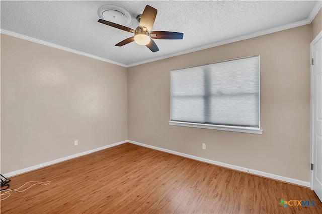 empty room with wood finished floors, a ceiling fan, baseboards, and ornamental molding