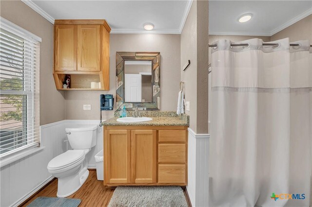 bathroom with wood finished floors, a wealth of natural light, ornamental molding, and toilet