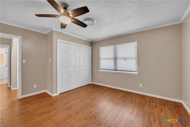unfurnished bedroom with baseboards, a closet, a textured ceiling, and light wood-type flooring