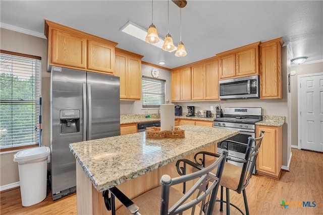 kitchen featuring light wood-style floors, crown molding, light stone countertops, a kitchen island, and appliances with stainless steel finishes