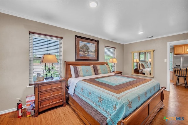 bedroom featuring crown molding, light wood-style flooring, stainless steel refrigerator with ice dispenser, visible vents, and recessed lighting