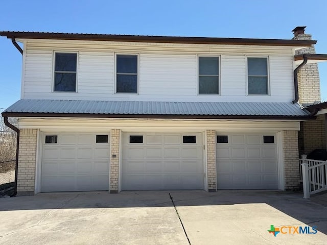 view of front of property with an attached garage, brick siding, and concrete driveway