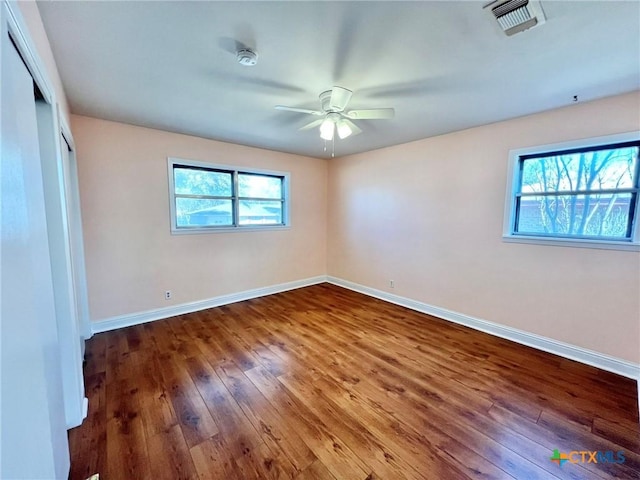 unfurnished bedroom with a closet, visible vents, hardwood / wood-style floors, ceiling fan, and baseboards