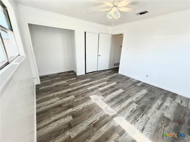 unfurnished bedroom with baseboards, wood finished floors, visible vents, and crown molding