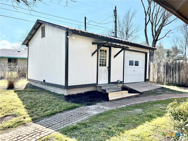 view of front of home with entry steps, fence, metal roof, and a front yard