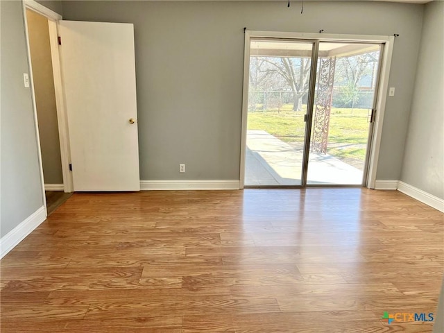 empty room with wood finished floors and baseboards