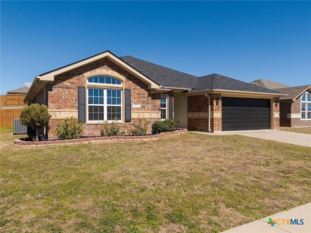 single story home featuring an attached garage, a front yard, and brick siding