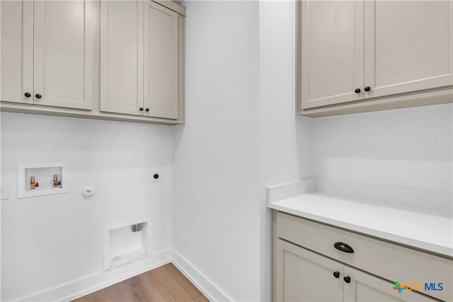 4018 Prairie Dr, Nolanville, TX 76559 - laundry room featuring cabinet space, electric dryer hookup, washer hookup, light wood-style floors, and hookup for a gas dryer