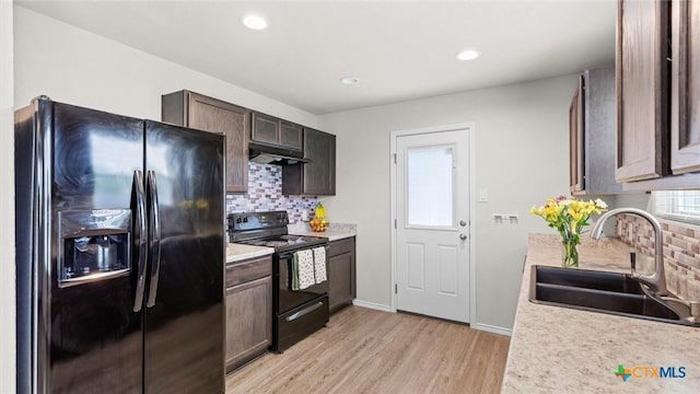 9741 Sandy Ridge Way, San Antonio, TX 78239 - kitchen featuring black appliances, decorative backsplash, light wood-style flooring, under cabinet range hood, and light countertops