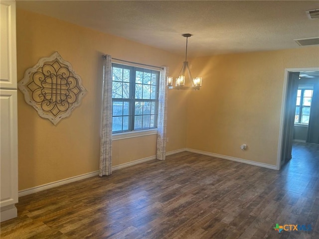 unfurnished dining area featuring dark wood-type flooring and ceiling fan with notable chandelier