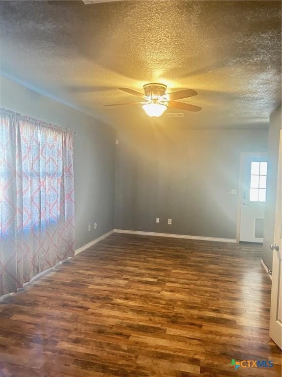 empty room featuring a textured ceiling, ceiling fan, and dark hardwood / wood-style flooring