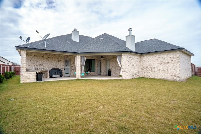 back of house with a yard, ceiling fan, and a patio area