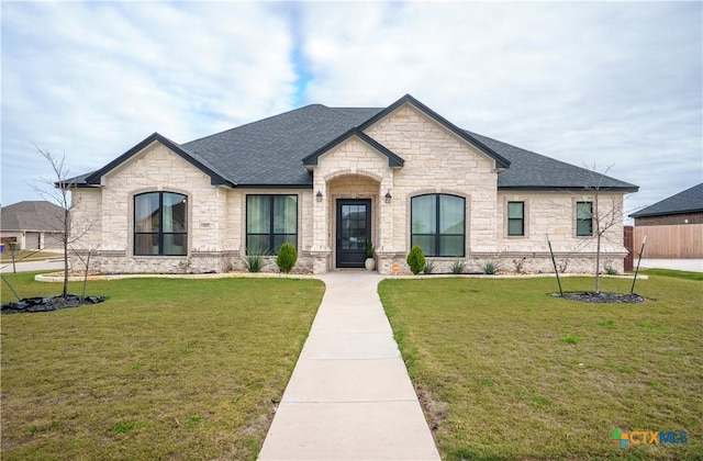 french country style house featuring a front yard