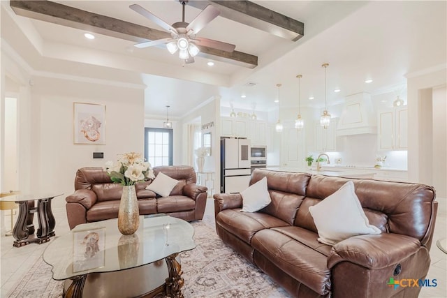 living room with ceiling fan, beam ceiling, ornamental molding, and sink