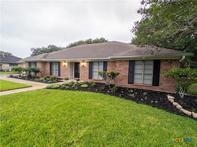 ranch-style home with a front lawn and brick siding