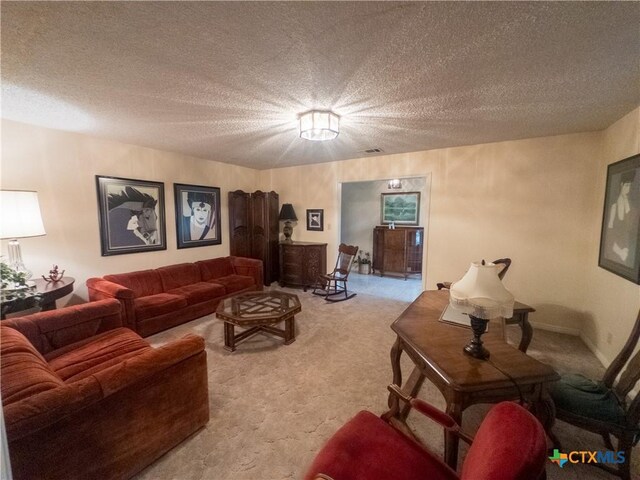 living area with light colored carpet and a textured ceiling