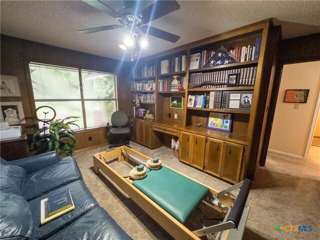 living area featuring a ceiling fan, a textured ceiling, and carpet flooring