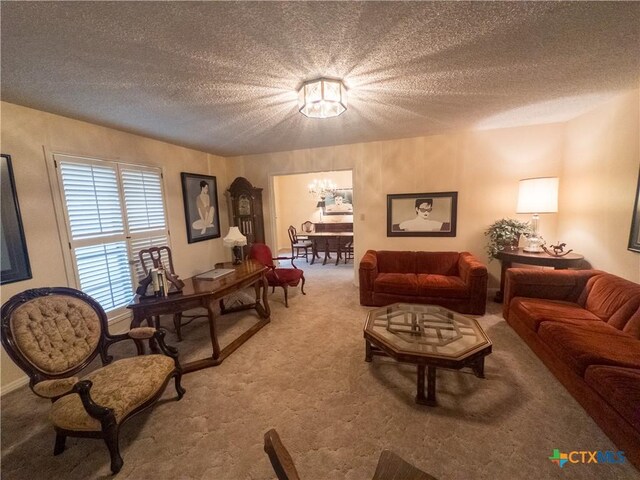 living area with a chandelier, carpet, and a textured ceiling