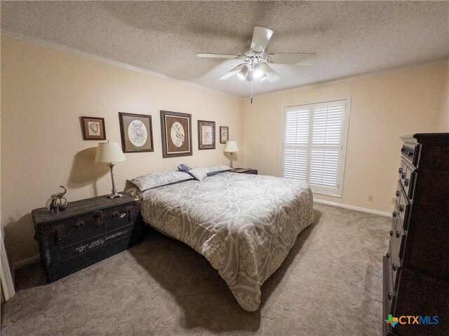 carpeted bedroom with a textured ceiling, ceiling fan, and baseboards