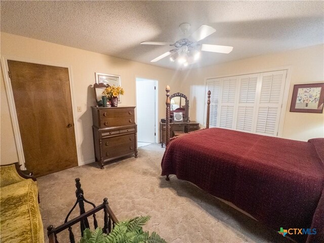 bedroom featuring light carpet, a textured ceiling, and a ceiling fan