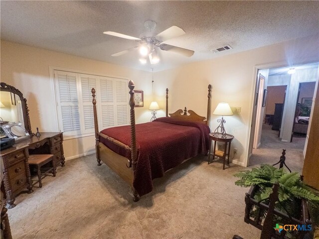 bedroom featuring light colored carpet, a textured ceiling, ceiling fan, and baseboards