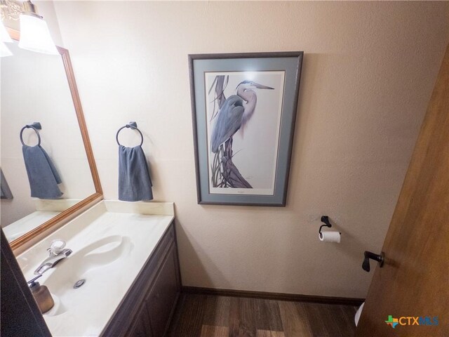 bathroom featuring wood finished floors, baseboards, and vanity