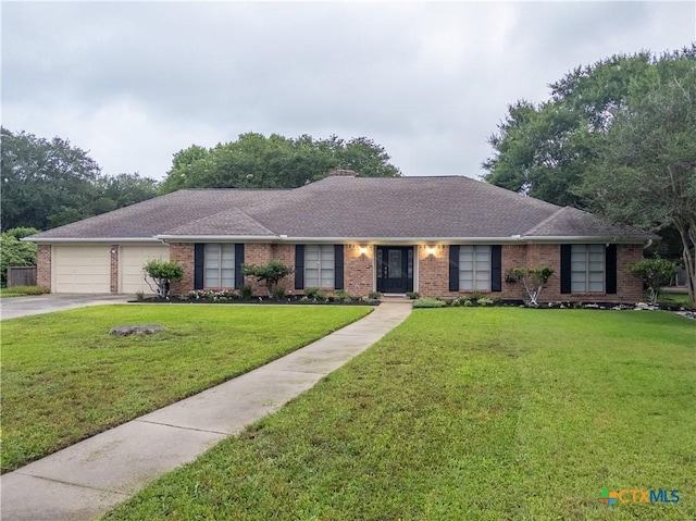ranch-style home with brick siding, an attached garage, a front lawn, driveway, and roof with shingles