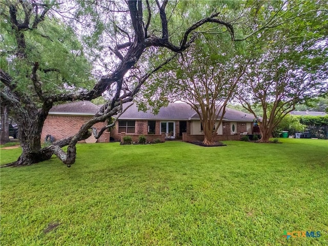 single story home featuring brick siding and a front yard