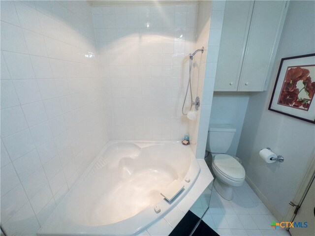 bathroom with baseboards, toilet, tile patterned flooring, and washtub / shower combination
