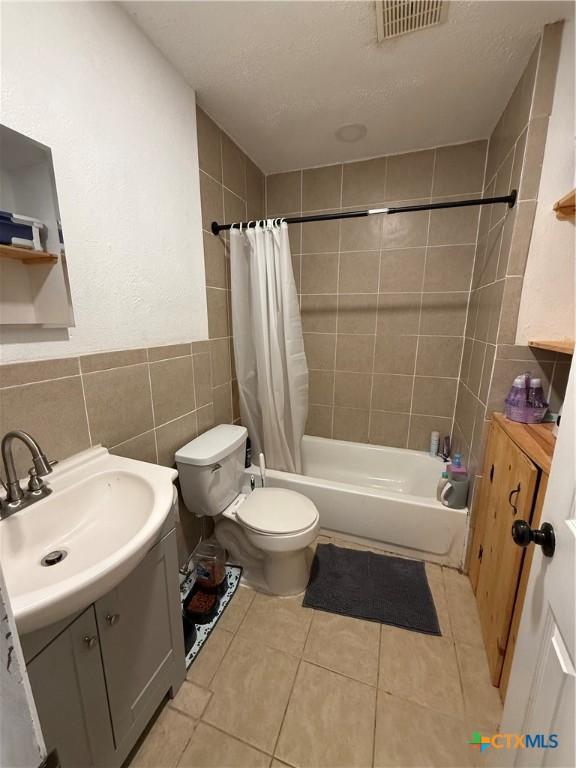 1403 Little St, Copperas Cove, TX 76522 - bathroom with tile walls, vanity, toilet, shower / bath combo, and tile patterned floors